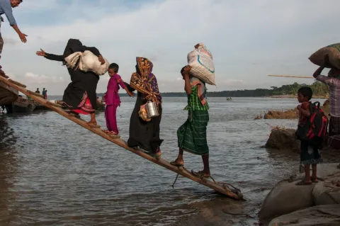 Climate-affected internally displaced persons board a boat to travel to Dhaka, Bangladesh.