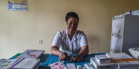 Nurse smiling and sitting at her desk