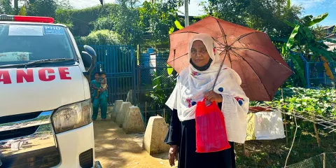 lady in asia sheltering from sun under umbrella