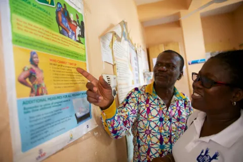 African man pointing at a chart in doctors office with a woman