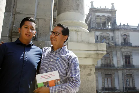 A man and his son holding the Mexico Advocacy Agenda