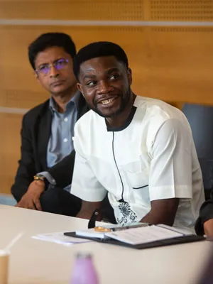 a young black man smiling at a meeting on ncd advocacy in Geneva