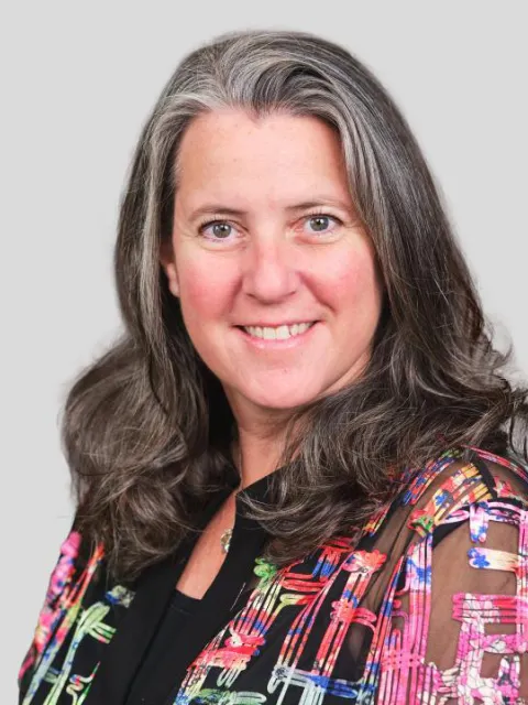 lady smiling for portrait with colourful top on