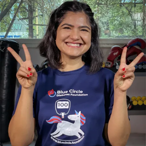 Woman holding up two peace signed smiling in victory