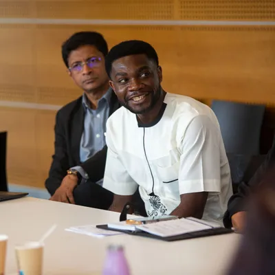 a young black man smiling at a meeting on ncd advocacy in Geneva