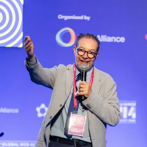 Mexican man Jaime Barba on stage lifting hand at Global NCD Alliance Forum 