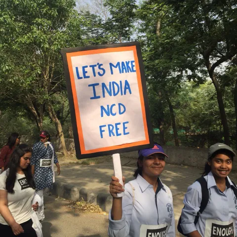 woman holding a placard that says Make India NCD free