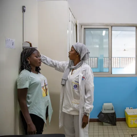 A young woman living with diabetes gets her height measured at a hospital 