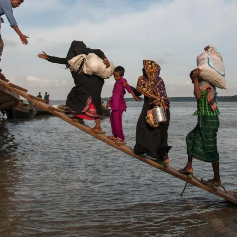  Climate-affected internally displaced persons board a boat to travel to Dhaka, Bangladesh. 