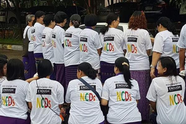 A dozen members of the Myanmar NCD Alliance wearing white T-shirts to mark the Global Week